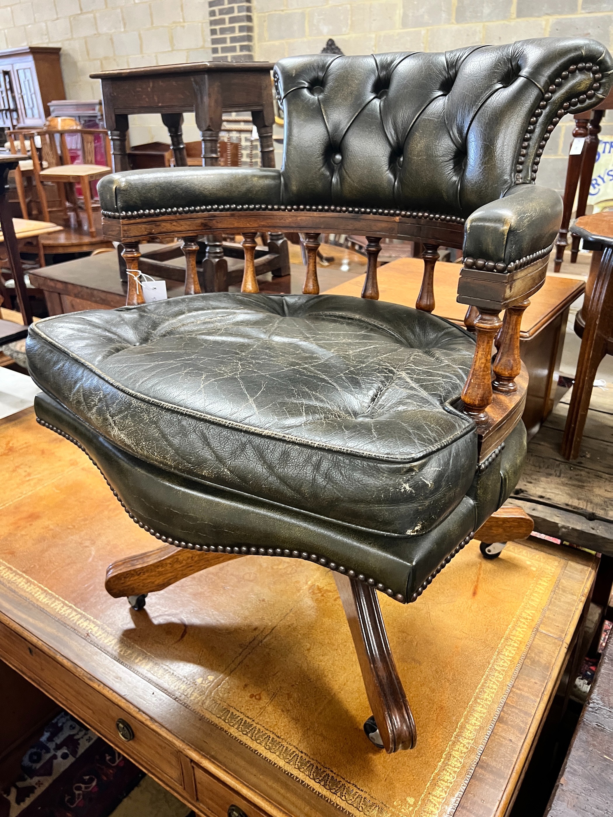 A Victorian style buttoned green leather mahogany swivel desk chair, width 62cm, depth 58cm, height 85cm